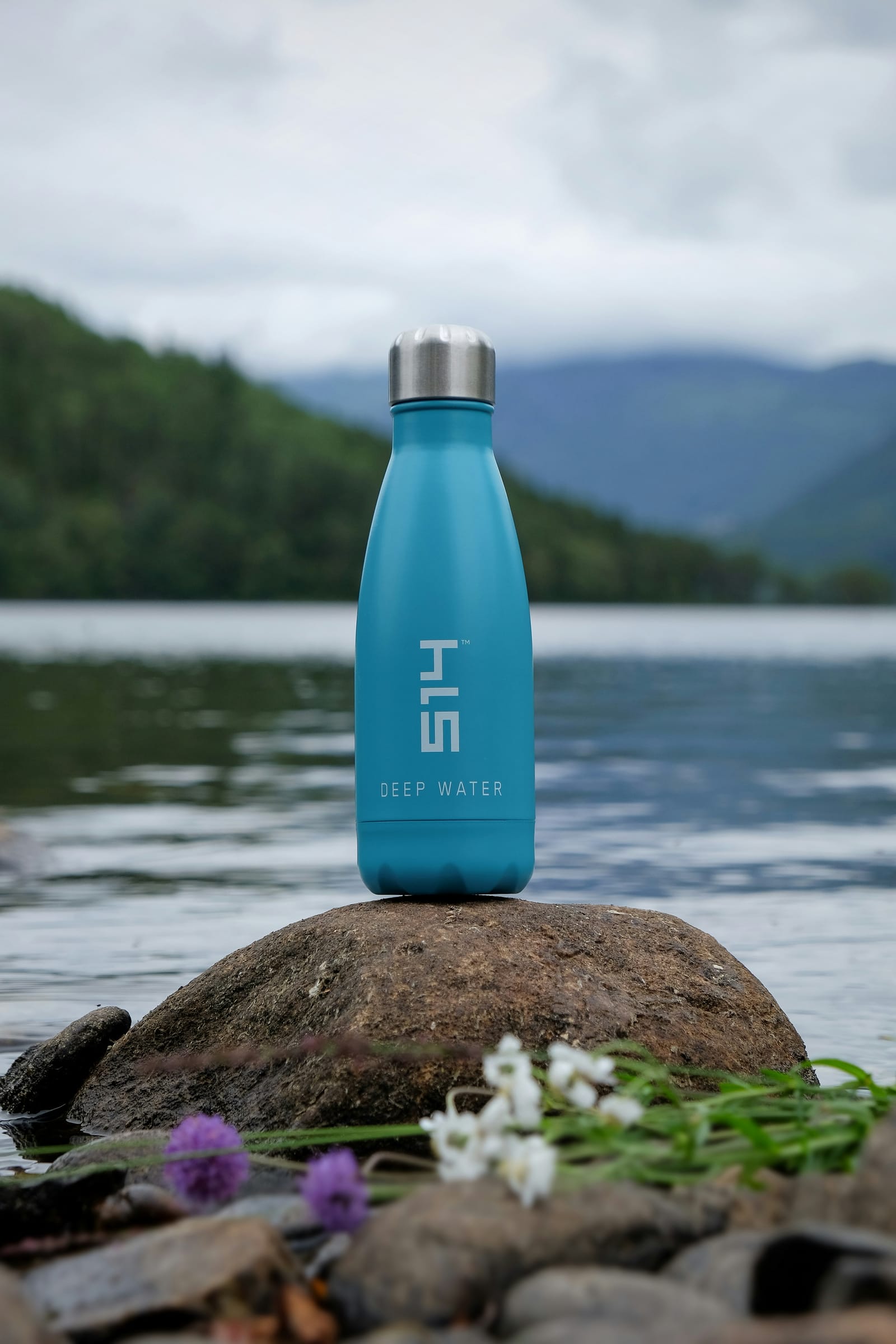 Bottle at the still edge of an alpine lake
