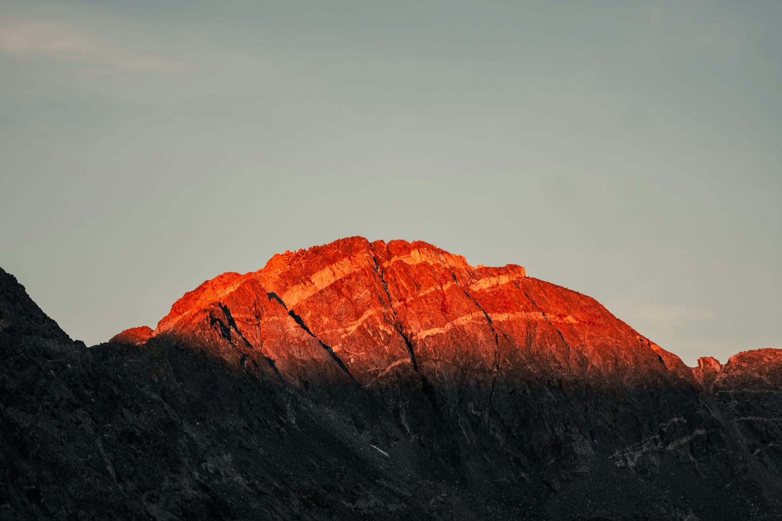 First light on a line of alpine peaks